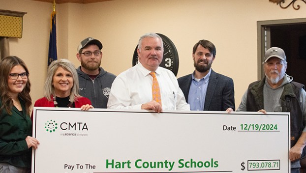 Hart County Schools Student Representative Emma Sanders, HCS School Board Vice Chairman Tina Rutledge, HCS School Board Member Tyler Holthouser, HCS Superintendent Nathan Smith, CMTA Project Manager Jason Pollan and HCS School Board Member Wesley Hodges pose for a picture with a $793,078.71 ceremonial check at the school board’s Thursday meeting, representing funds of the same amount earned through the installation of a geothermal well field.