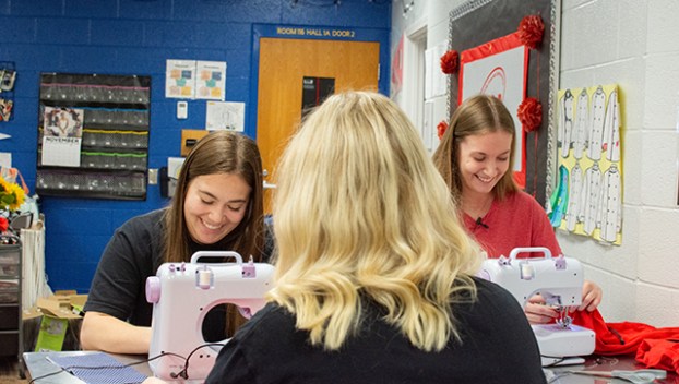 Warren East High School students Avery Gidcumb, Taylor Mills and Jamie Phelps sew ChemoComfort products Nov. 26 in their schools culinary lab. (David Mamaril Horowitz)