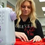 Warren East High School student Taylor Mills works on a ChemoComfort shirt at the school culinary lab on Nov. 26.