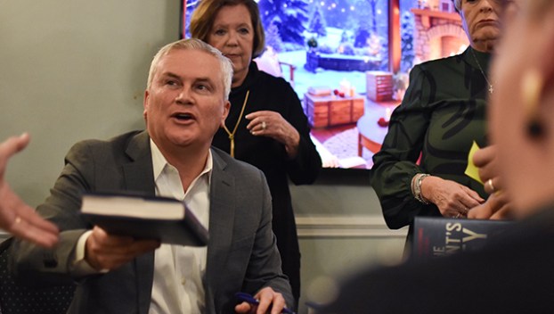 U.S. Rep. James Comer, R-Kentucky, chairman of the House Oversight Committee, hands a signed copy of his book “All the President’s Money” to an attendee at his Friday book-signing at the Bowling Green Country Club.