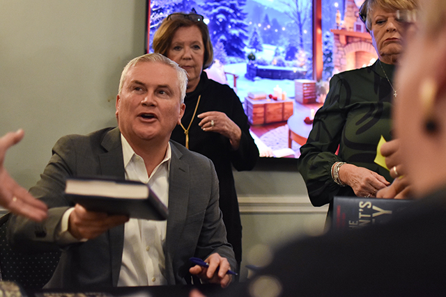 U.S. Rep. James Comer, R-Kentucky, chairman of the House Oversight Committee, hands a signed copy of his book “All the President’s Money” to an attendee at his Friday book-signing at the Bowling Green Country Club.