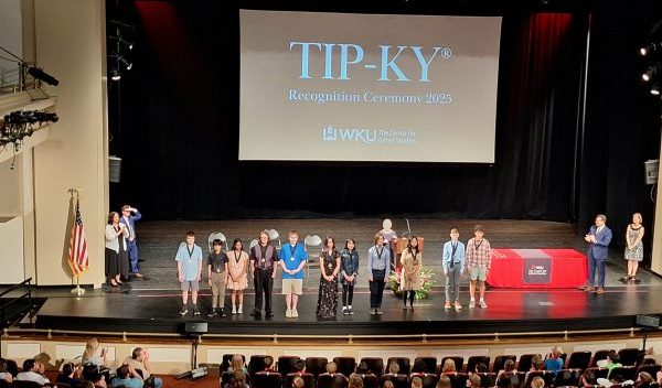 Picture of students being honored on the stage at WKU's Van Meter Auditorium for their accomplishments in TIP-KY testing, with a crowd in the foreground