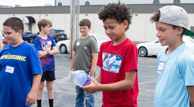 Picture of Rivez Myers, 10, holding onto a Pepsi bottle that’ll be turned into a rocket with vinegar and baking soda Monday.