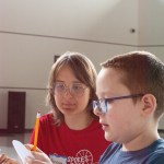 Picture of MIT student Ramona Poreitere helping Demitri Burris, 10, with a Caesarian cipher.