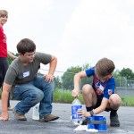 Picture of two kids preparing a bottle rocket