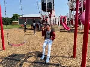Picture of then-Teranga Academy student Ernesto Manuel-Andres sits on a swing at Chaney's Dairy Barn during a field trip last summer. (SUBMITTED)