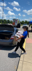 Picture of WCPS Nutrition & Dining Supervisor Brooke Graham bringing meals to a car at South Warren Middle on July 8.