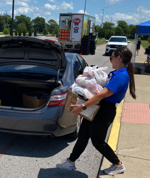 Picture of WCPS Nutrition & Dining Supervisor Brooke Graham bringing meals to a car at South Warren Middle on July 8.