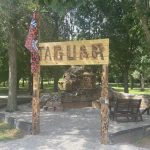 Picture of a Natcher Elementary flag raised in front of the sculpture J.J. the Jaguar Giant.