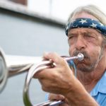 Photograph of Timothy Alexander playing "Taps" on the bugle.
